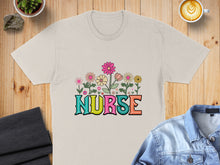Load image into Gallery viewer, Beige t-shirt with colorful floral "NURSE" text graphic.