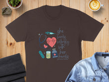 Load image into Gallery viewer, Brown t-shirt with "she works willingly with her hands" and medical icons.