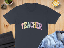 Load image into Gallery viewer, Dark gray t-shirt with "TEACHER" in pastel rainbow lettering.