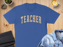 Load image into Gallery viewer, Blue t-shirt with "TEACHER" in floral block lettering.