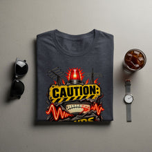 Load image into Gallery viewer, Dark gray t-shirt with "CAUTION:" warning sign and gauge graphic.