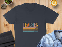 Load image into Gallery viewer, Dark grey t-shirt with "TEACHER" text and inspirational words on colored stripes.