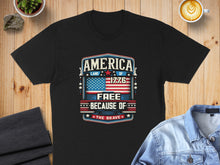 Load image into Gallery viewer, Black t-shirt with "America Land of the Free Because of the Brave" text and flag design.