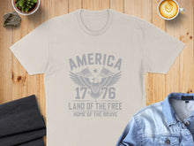 Load image into Gallery viewer, Light gray t-shirt with "America 1776 Land of the Free Home of the Brave" text and eagle graphic.