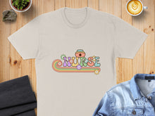 Load image into Gallery viewer, Cream t-shirt with "NURSE" text and floral rainbow design.