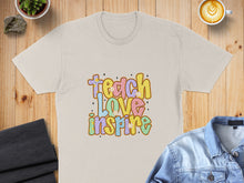 Load image into Gallery viewer, Beige t-shirt with "Teach Love Inspire" text in colorful bubble letters.