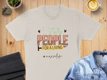Load image into Gallery viewer, Cream t-shirt with "I stab people for a living #nurselife" text.