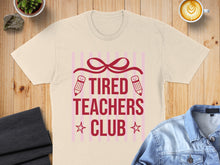 Load image into Gallery viewer, Tired Teachers Club text with pencils and stars on a cream t-shirt.