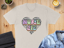 Load image into Gallery viewer, Heart graphic with "Nurse Life" text on a beige t-shirt.