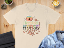 Load image into Gallery viewer, Livin' That Nurse Life text with heart and stethoscope graphic on t-shirt.