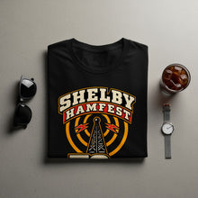 Load image into Gallery viewer, Black t-shirt with "SHELBY HAMFEST" text and radio tower graphic.