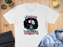 Load image into Gallery viewer, T-shirt with "Nursing is a work of Heart" text and a nurse character.