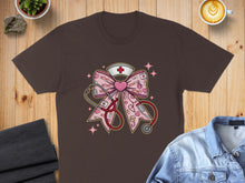 Load image into Gallery viewer, Brown t-shirt featuring a pink bow with stethoscope and nurse cap, decorated with XOXO.