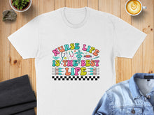 Load image into Gallery viewer, T-shirt with "Nurse Life Is The Best Life" text, stethoscope, and medical icons.