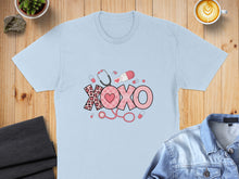 Load image into Gallery viewer, Light blue t-shirt with pink "XOXO" text, stethoscope, and medical icons.