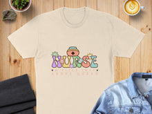 Load image into Gallery viewer, Cream t-shirt with "NURSE ABOVE QUEEN" text and floral accents.