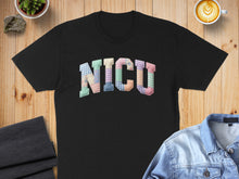 Load image into Gallery viewer, Black t-shirt with "NICU" in colorful patchwork letters.