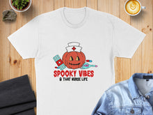 Load image into Gallery viewer, White t-shirt with Halloween pumpkin nurse, bandages, and thermometer, reading "Spooky Vibes & That Nurse Life".