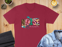 Load image into Gallery viewer, Burgundy t-shirt with "Nurse in Progress" text and medical graphics.
