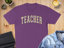Load image into Gallery viewer, Purple t-shirt with "TEACHER" text in floral pattern.