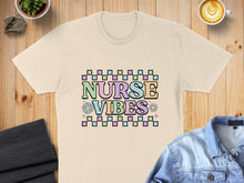 Load image into Gallery viewer, T-shirt with "NURSE VIBES" text in colorful pastel checkered font.