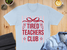 Load image into Gallery viewer, Light blue t-shirt with red text "TIRED TEACHERS CLUB" and pencil graphics.