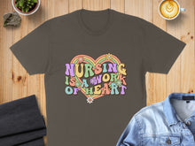 Load image into Gallery viewer, Retro groovy graphic t-shirt with "Nursing is a work of heart" text and flowers.