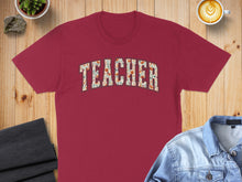 Load image into Gallery viewer, Maroon t-shirt with "TEACHER" in a floral arch pattern.