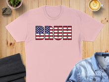 Load image into Gallery viewer, Pink t-shirt with "BRUH" in American flag text, flat lay with coffee and denim.
