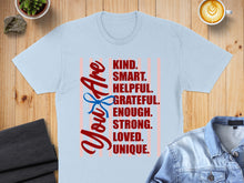 Load image into Gallery viewer, Light blue t-shirt with "You Are KIND. SMART. HELPFUL. GRATEFUL. ENOUGH. STRONG. LOVED. UNIQUE." text.