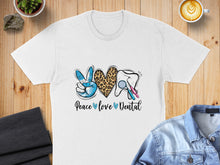 Load image into Gallery viewer, White t-shirt with "Peace love Dental" text and dental graphic.