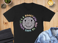 Load image into Gallery viewer, Black t-shirt with a colorful leopard print smiley face and "It's a beautiful day to save lives" text.
