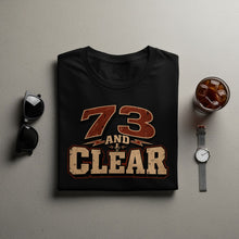 Load image into Gallery viewer, Black t-shirt with "73 AND CLEAR" graphic and a microphone icon.
