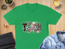 Load image into Gallery viewer, Green t-shirt with "TEACH" graphic featuring books, apple, and leopard print.
