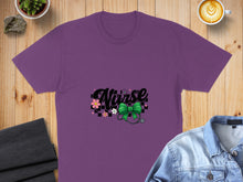 Load image into Gallery viewer, Purple t-shirt with "Nurse" text, stethoscope, and green bow.
