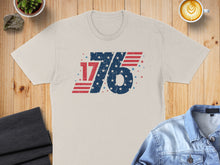 Load image into Gallery viewer, Light tan t-shirt with distressed "1776" American flag design.
