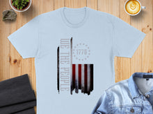 Load image into Gallery viewer, Light blue t-shirt with distressed American flag and "WE THE PEOPLE" text.
