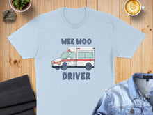 Load image into Gallery viewer, Light blue t-shirt with "WEE WOO DRIVER" and an ambulance graphic.
