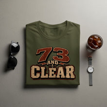 Load image into Gallery viewer, Olive green t-shirt with "73 AND CLEAR" graphic and microphone logo
