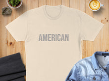 Load image into Gallery viewer, Cream t-shirt with "AMERICAN" text across the chest, styled with denim and coffee.

