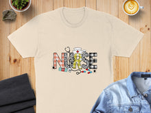 Load image into Gallery viewer, Cream t-shirt with "NURSE" spelled out in patterned letters, stethoscope, and medical icons.
