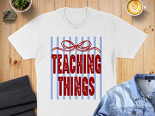 Load image into Gallery viewer, White t-shirt with red "Teaching Things" text and blue stripes.
