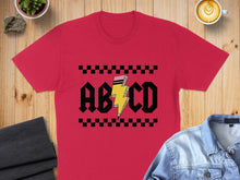 Load image into Gallery viewer, Red t-shirt with "ABCD" and lightning bolt graphic on black and white checkerboard background.
