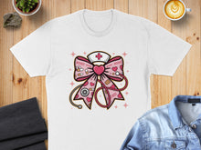 Load image into Gallery viewer, White t-shirt with nurse-themed bow graphic featuring hearts and stethoscope.
