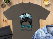 Load image into Gallery viewer, Brown t-shirt with "#NurseLife" graphic featuring messy bun and medical icons.
