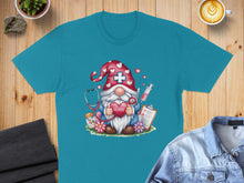 Load image into Gallery viewer, Teal t-shirt with a gnome nurse design holding a heart and stethoscope.
