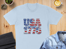 Load image into Gallery viewer, Light blue t-shirt with "USA 1776" in stars and stripes design.
