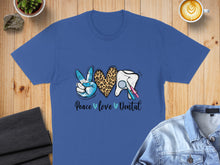 Load image into Gallery viewer, Blue t-shirt with peace sign, leopard print heart, tooth, and dental tools.
