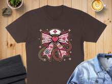 Load image into Gallery viewer, Brown t-shirt with pink ribbon stethoscope heart nurse cap and XO XO XO pattern.

