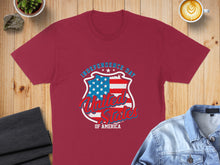 Load image into Gallery viewer, Burgundy t-shirt with "Independence Day United States of America" shield graphic.
